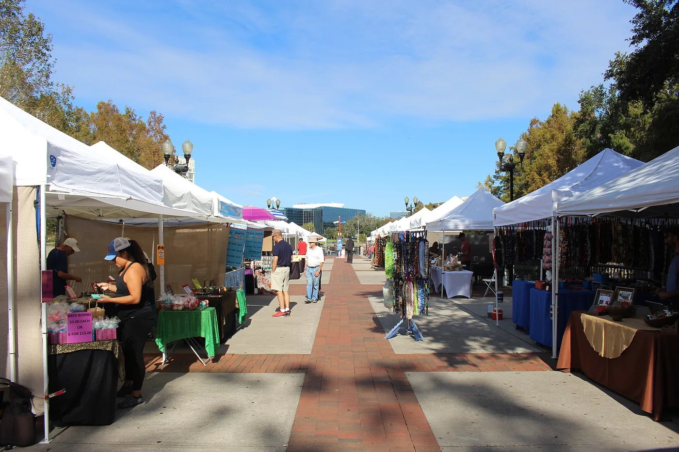 Shoppers and vendor tents at the Orlando Farmers Market in Lake Eola Park