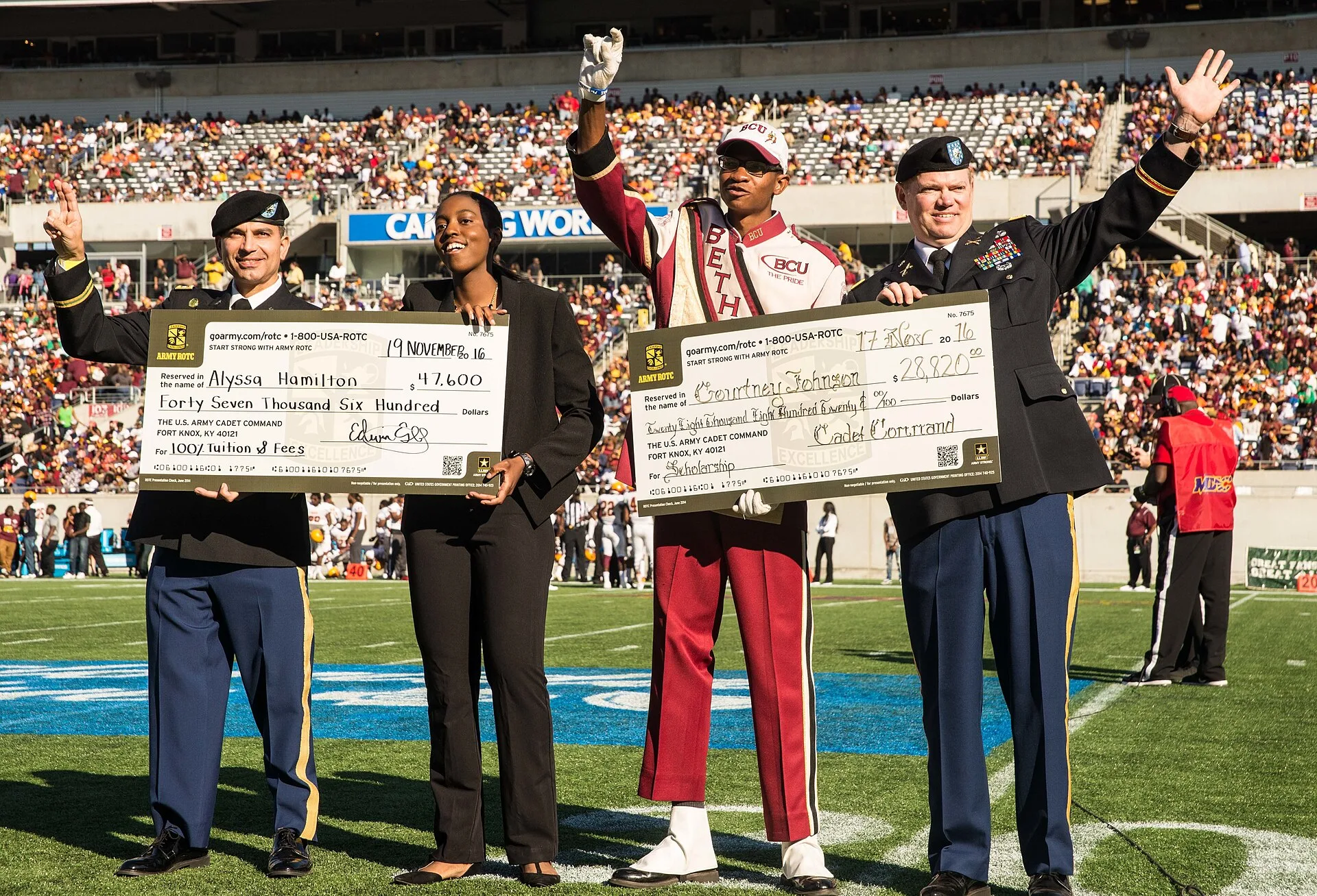 Students from Florida A&M and Bethune-Cookman, including a Bethune-Cookman drum major, on the field with Army officers during the Florida Classic at Camping World Stadium