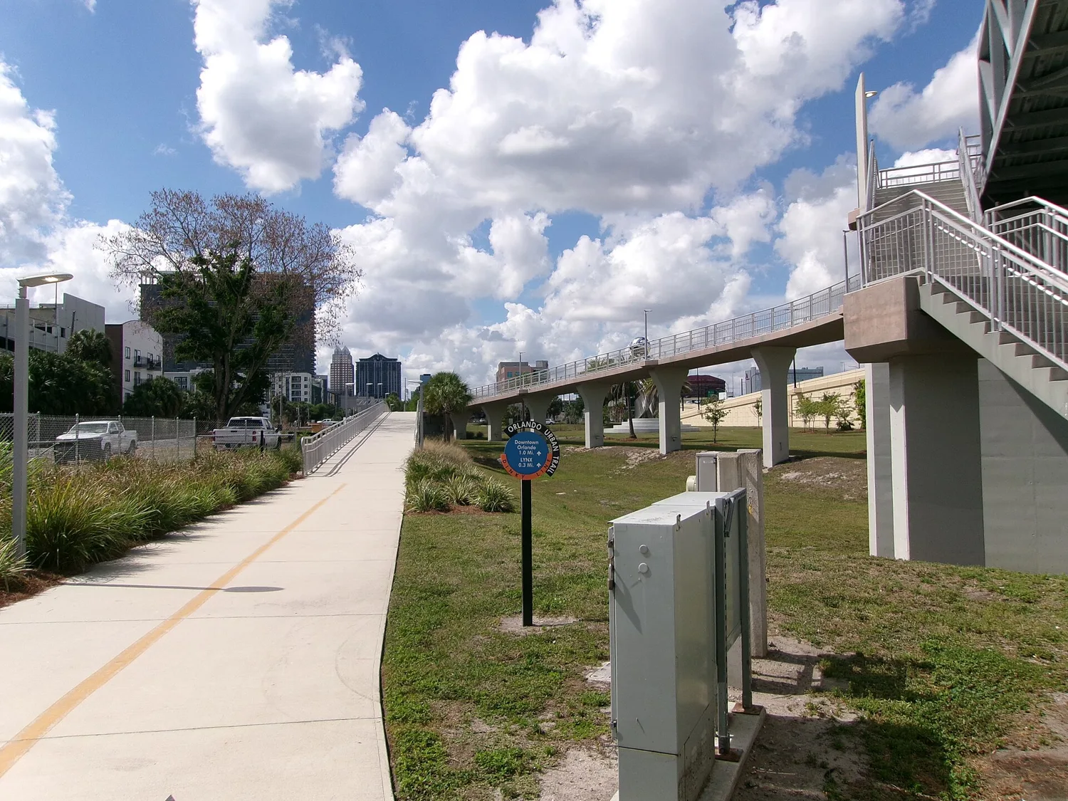 The Orlando Urban Trail beside the Colonial Drive pedestrian bridge, with a sign pointing a mile to downtown